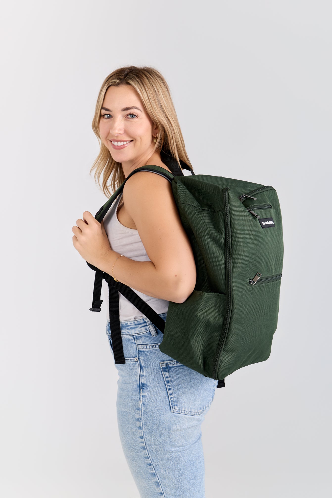 Woman wearing a green backpack on a white background
