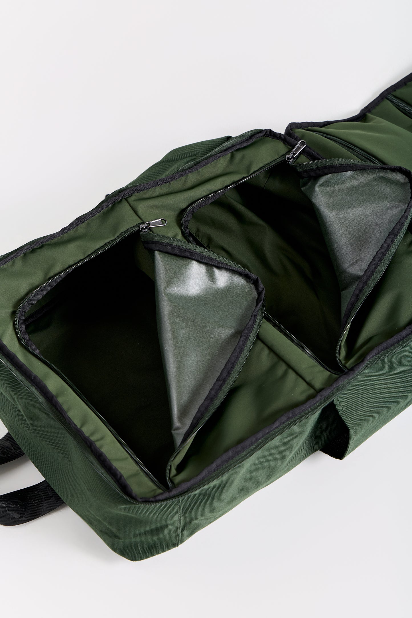 Green bag with open compartments on a white background