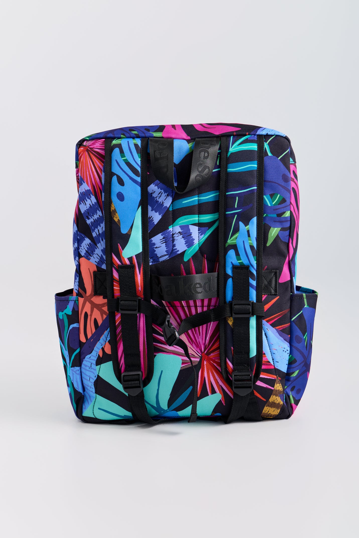 Colorful backpack with tropical leaf pattern on a white background