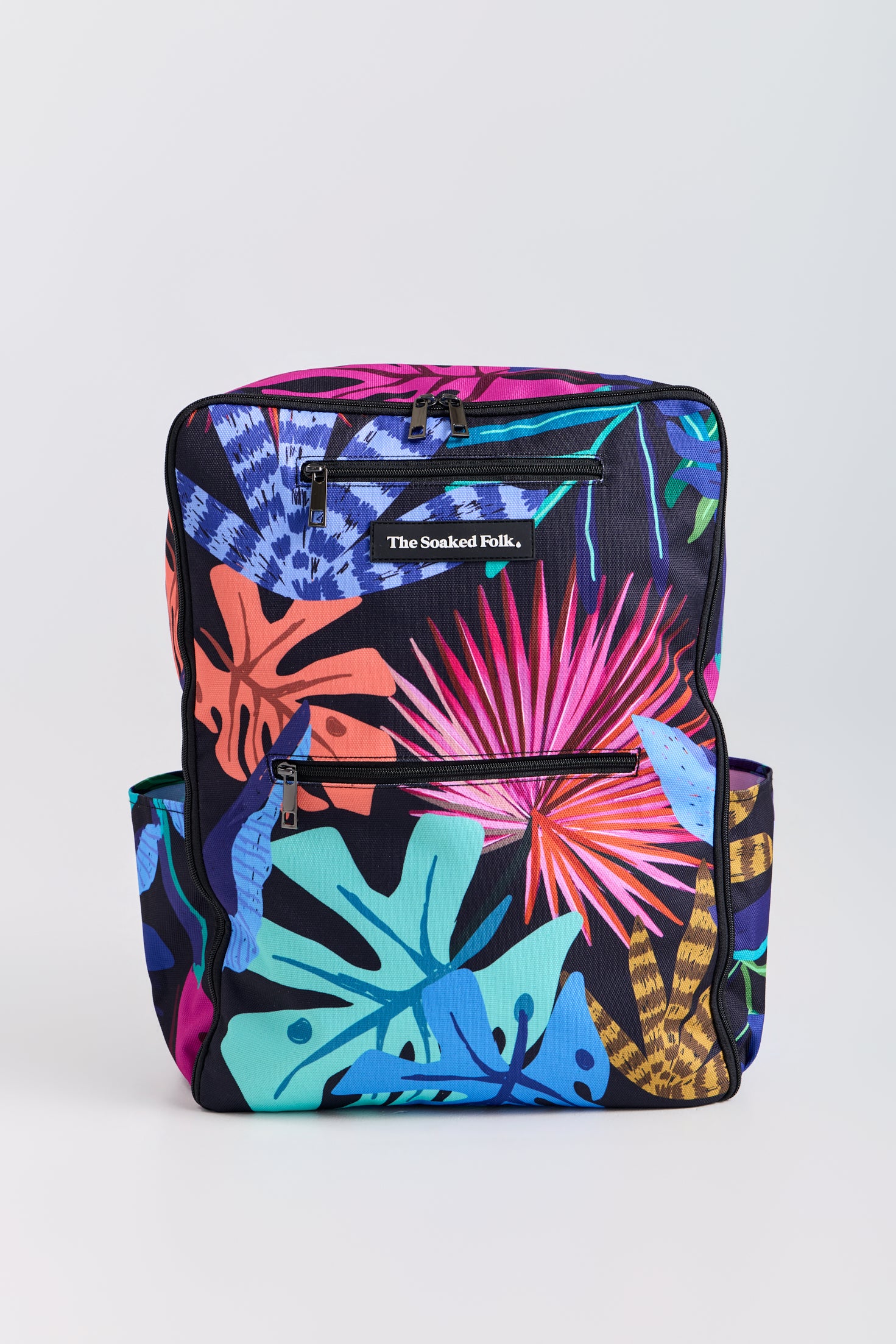 Backpack with colorful tropical leaf pattern on a light gray background